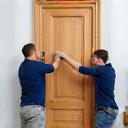 Team installing a newly crafted timber door.